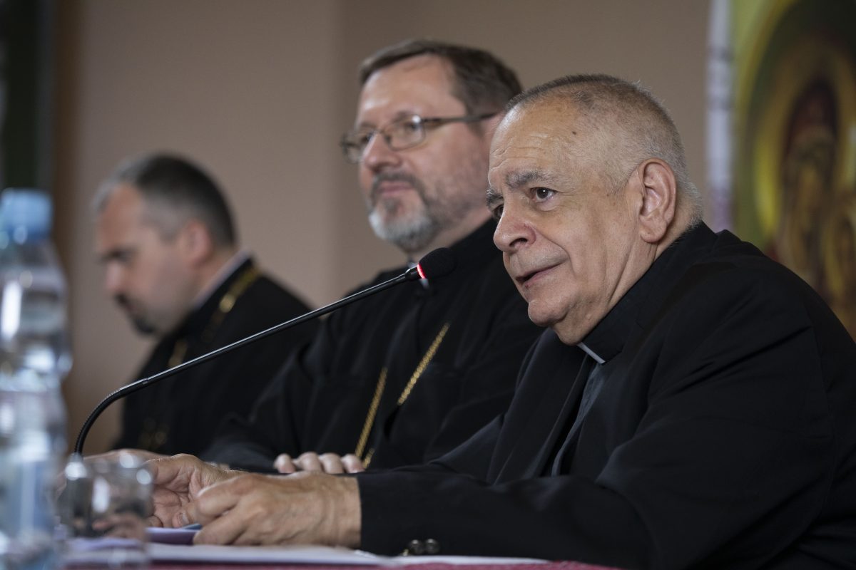 Msgr. Robert J. Vitillo speaking seated before a microphone