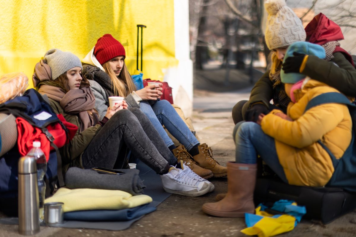 Young Ukrainian refugees wait at a border crossing into Europe